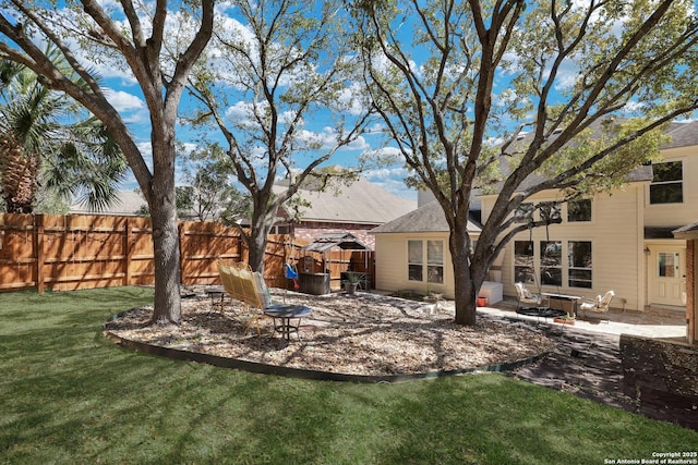 view of yard with fence, an outdoor fire pit, and a patio area