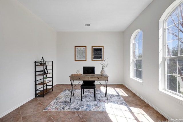 tiled office featuring visible vents, plenty of natural light, and baseboards