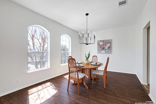 dining area with visible vents, baseboards, an inviting chandelier, and wood finished floors