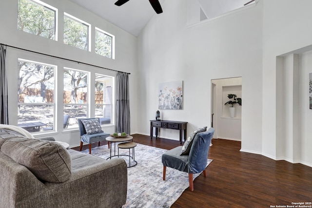 living room with a ceiling fan, wood finished floors, baseboards, and high vaulted ceiling