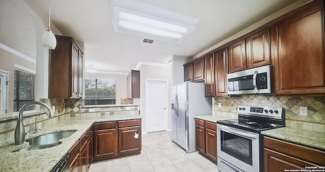 kitchen featuring tasteful backsplash, stainless steel appliances, crown molding, and a sink