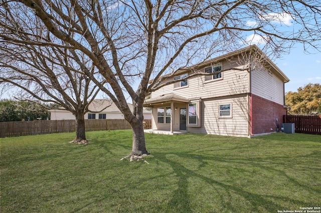 rear view of house with fence, a lawn, and central AC