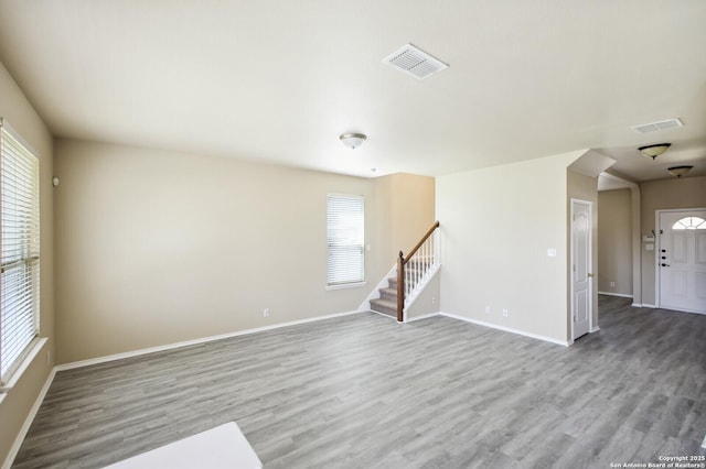 interior space featuring visible vents, stairs, baseboards, and wood finished floors