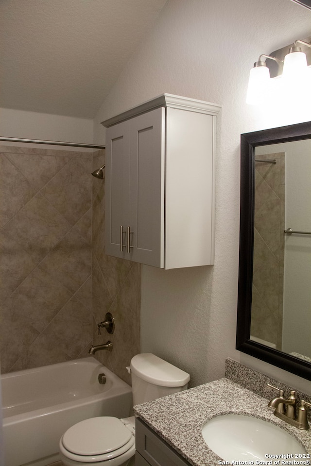 full bath with toilet, lofted ceiling, bathtub / shower combination, vanity, and a textured wall