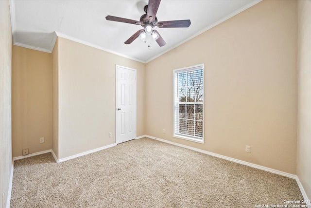 carpeted spare room with baseboards, a ceiling fan, and crown molding