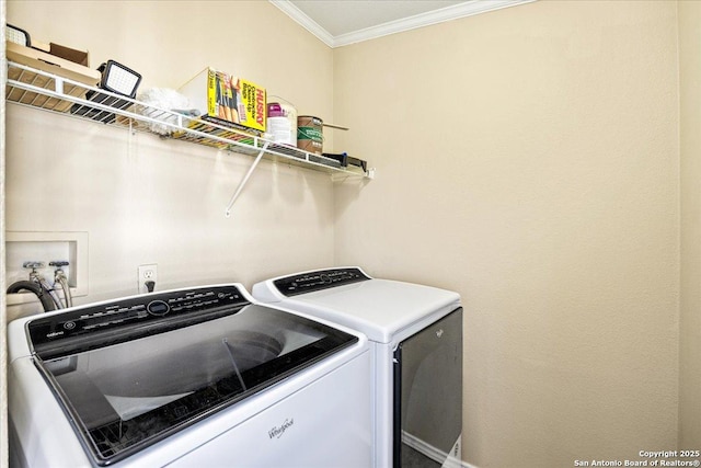 laundry room featuring laundry area, ornamental molding, and washer and clothes dryer