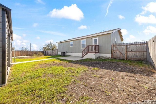 rear view of house featuring a gate, a patio, a fenced backyard, cooling unit, and a yard