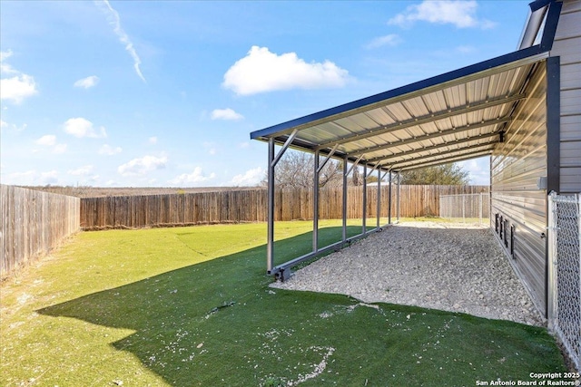 view of yard with a detached carport and a fenced backyard