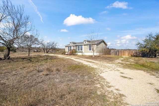 view of front of property with driveway and fence