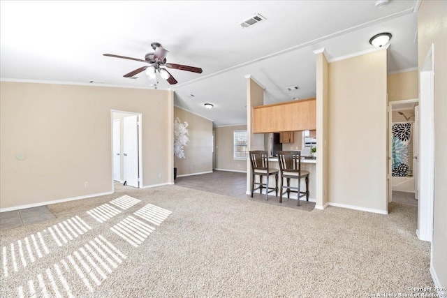 living area with crown molding, light colored carpet, visible vents, and vaulted ceiling