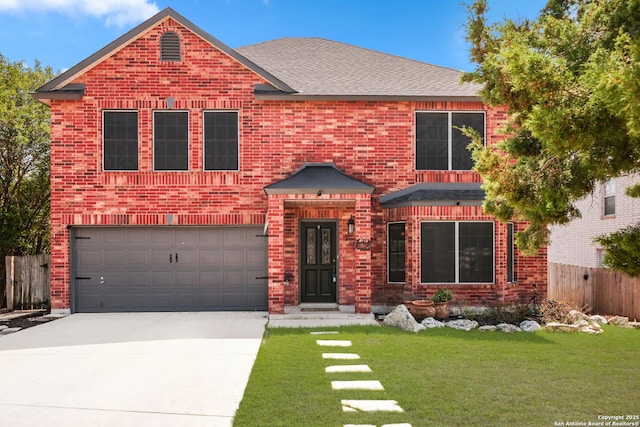 traditional-style house with brick siding, fence, concrete driveway, a front yard, and a garage