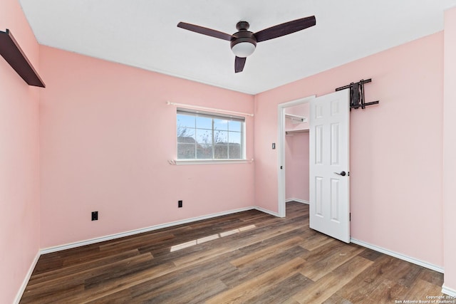 unfurnished bedroom featuring a closet, a ceiling fan, baseboards, and wood finished floors