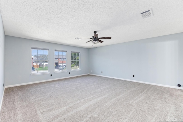 unfurnished room featuring visible vents, carpet flooring, a ceiling fan, and baseboards