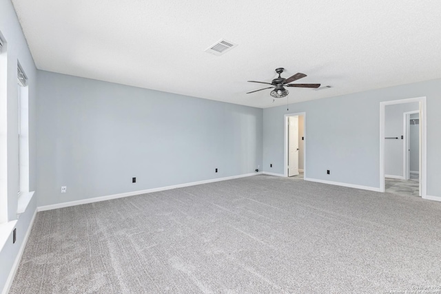 spare room with visible vents, carpet, baseboards, a textured ceiling, and a ceiling fan