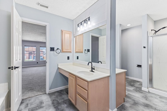 bathroom featuring visible vents, baseboards, a stall shower, a textured ceiling, and vanity