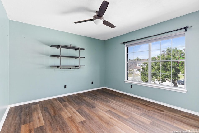 spare room with wood finished floors, baseboards, and ceiling fan