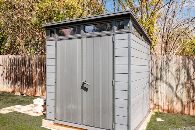 view of shed featuring fence