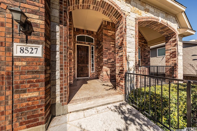 entrance to property featuring brick siding and a porch