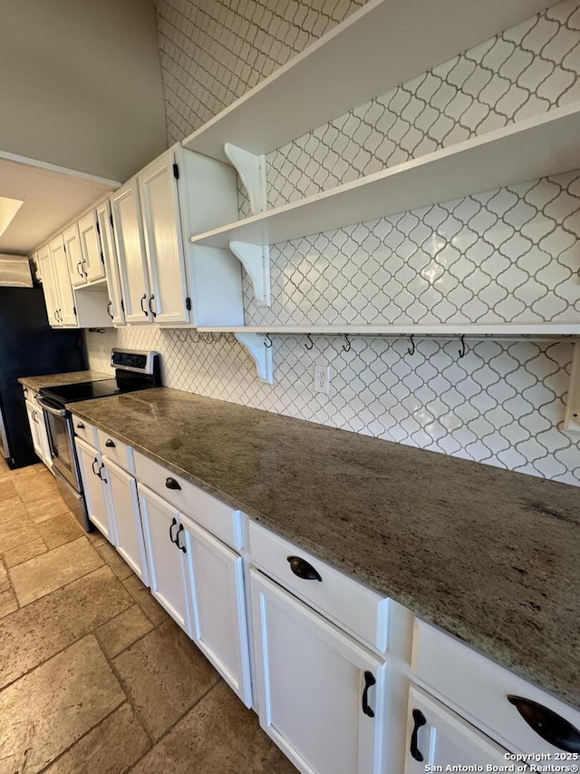 kitchen featuring stone tile floors, open shelves, stainless steel range with electric stovetop, white cabinets, and tasteful backsplash