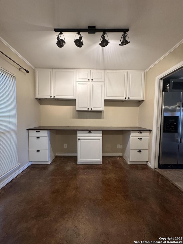 kitchen with stainless steel refrigerator with ice dispenser, white cabinets, and built in desk