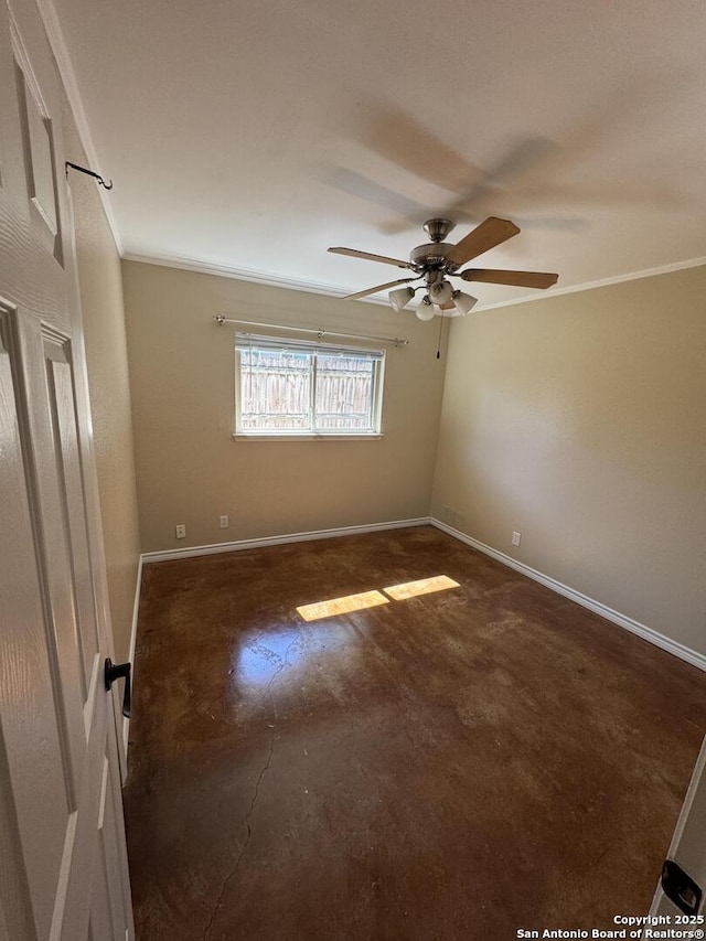 spare room featuring baseboards, concrete floors, and crown molding