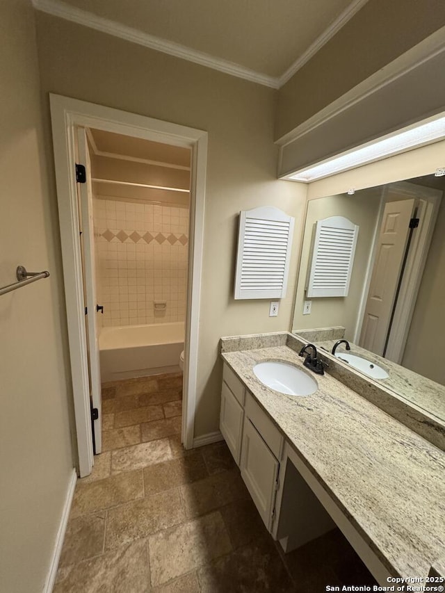 full bath with baseboards, stone tile floors, and ornamental molding