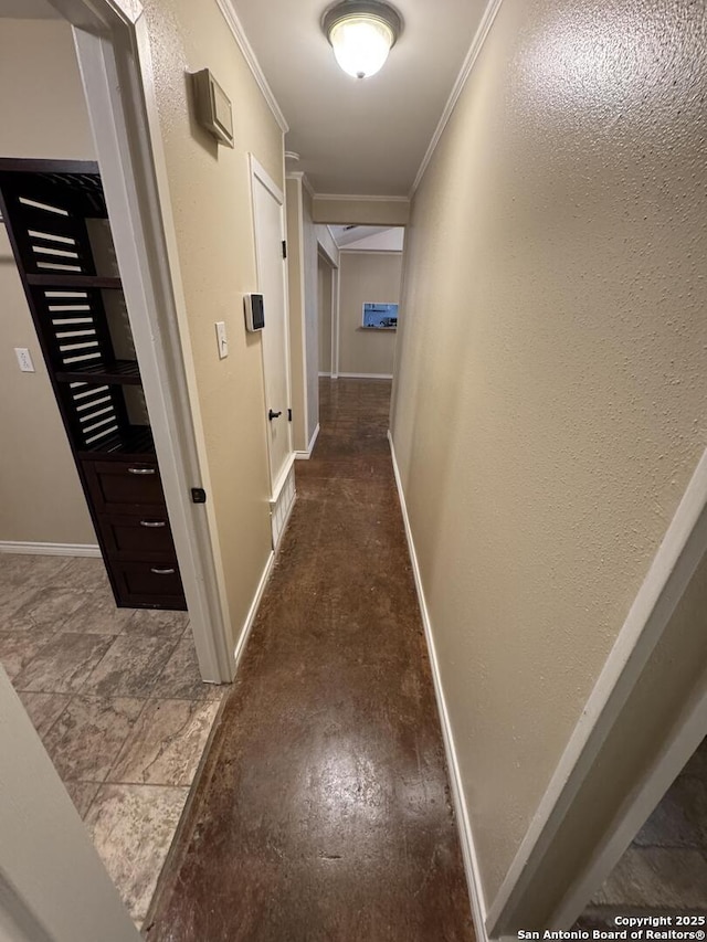 hallway with baseboards, crown molding, and a textured wall