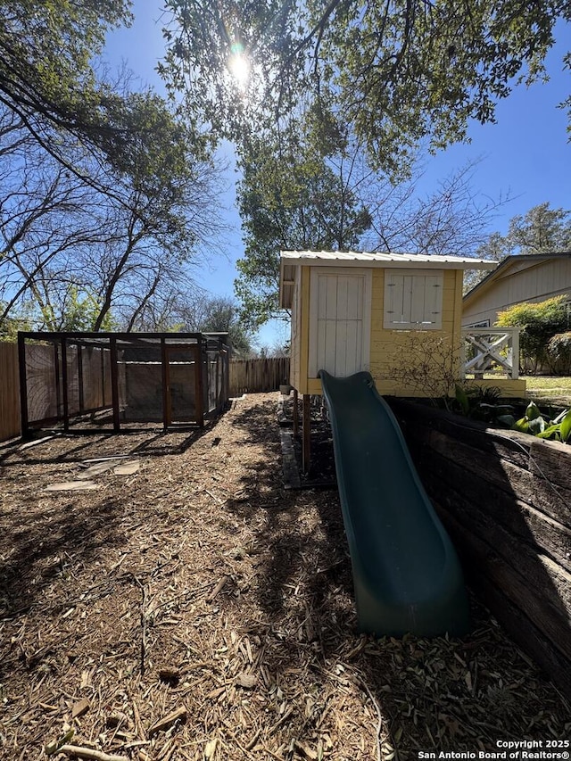 view of yard featuring an outdoor structure and fence