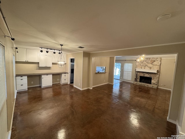 unfurnished living room featuring a stone fireplace, baseboards, concrete floors, and built in study area