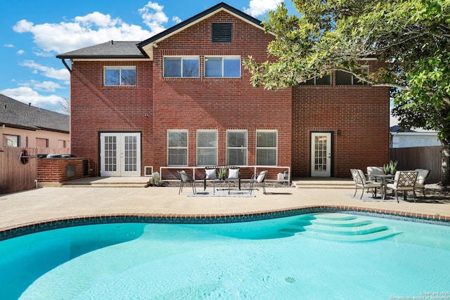 view of swimming pool featuring a patio, a fenced in pool, french doors, and fence