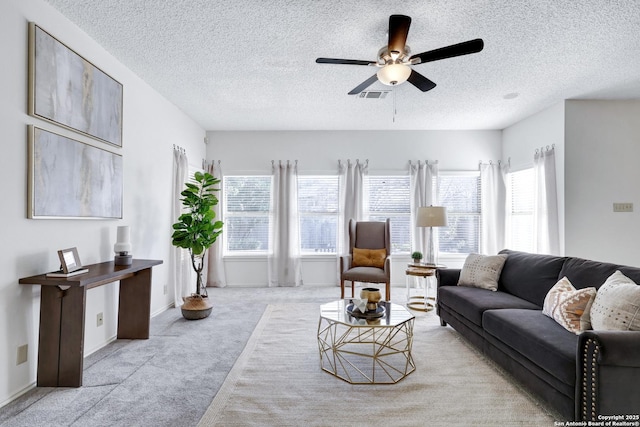 living room with visible vents, ceiling fan, a textured ceiling, and carpet