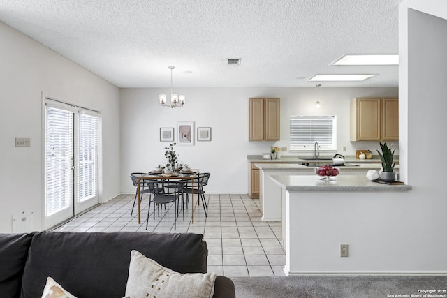 kitchen with light brown cabinetry, light tile patterned floors, and visible vents