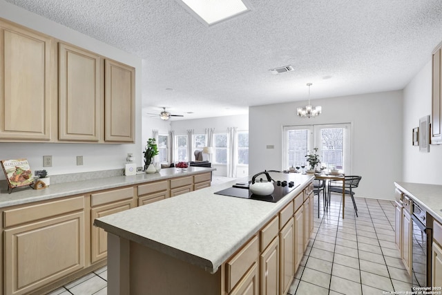 kitchen with light tile patterned floors, black electric cooktop, light brown cabinets, and light countertops