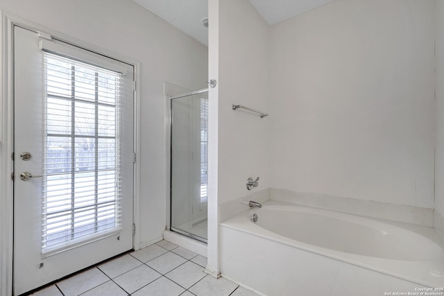 full bathroom with tile patterned flooring, a bath, and a stall shower