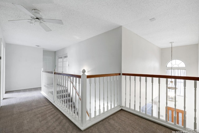 hallway with carpet flooring and a textured ceiling