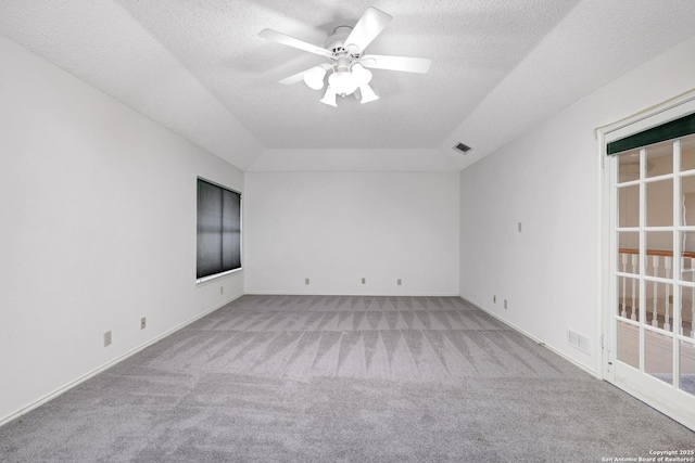 spare room with visible vents, carpet, a ceiling fan, and a textured ceiling