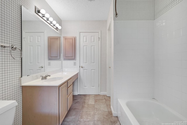 bathroom featuring bathing tub / shower combination, a textured ceiling, vanity, and toilet