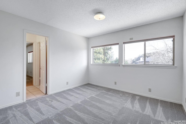 unfurnished bedroom featuring baseboards, carpet, and a textured ceiling