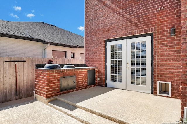 view of patio featuring exterior kitchen, french doors, and fence