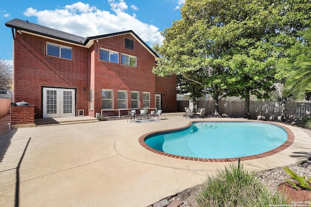 view of pool with a patio area, a fenced in pool, french doors, and fence