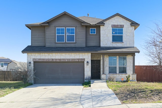 view of front of house with fence, driveway, roof with shingles, an attached garage, and stone siding