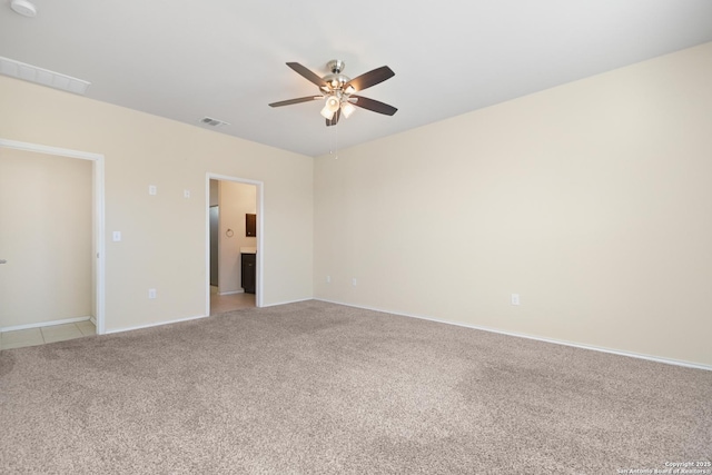 spare room with visible vents, light carpet, baseboards, and ceiling fan