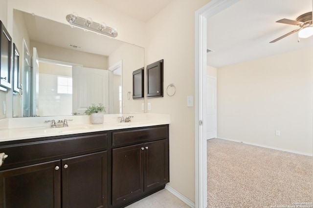 bathroom with visible vents, baseboards, double vanity, ceiling fan, and a sink