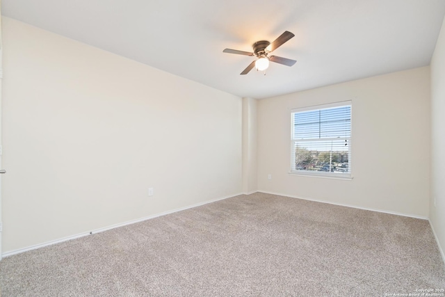 carpeted empty room featuring baseboards and ceiling fan