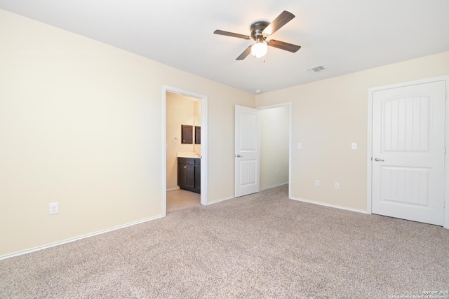 unfurnished bedroom featuring visible vents, connected bathroom, baseboards, ceiling fan, and light carpet