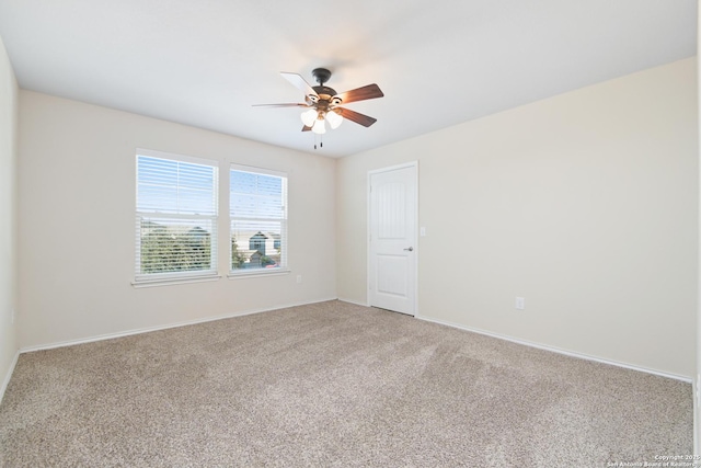 empty room featuring a ceiling fan, baseboards, and light carpet