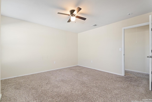 carpeted empty room featuring visible vents, baseboards, and a ceiling fan