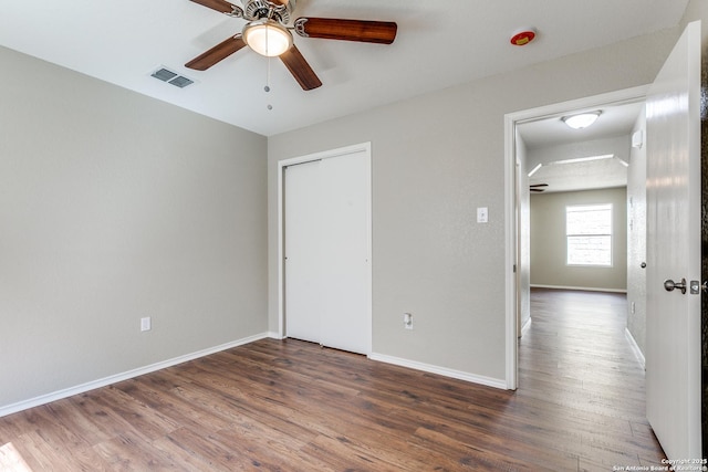 unfurnished bedroom with visible vents, baseboards, a closet, and wood finished floors