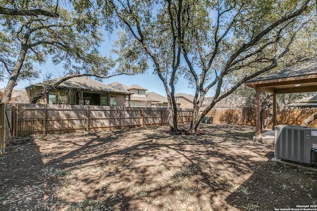 view of yard featuring a fenced backyard and central AC