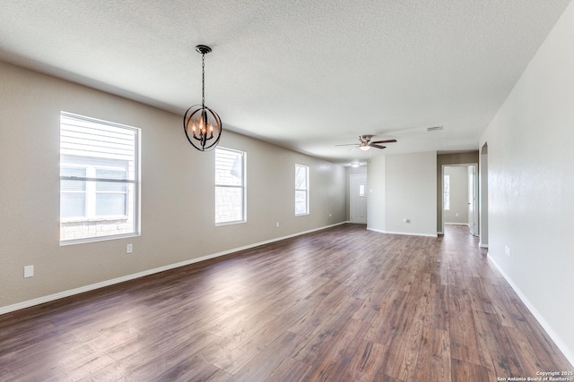 unfurnished room with visible vents, baseboards, dark wood-style flooring, a textured ceiling, and ceiling fan with notable chandelier